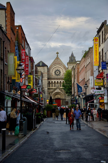 Shoppers on Grafton Street in Dublin, Ireland, with shopfronts and Saint Ann's Church in the background