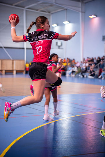 Handball player jumping and throwing the ball during a match