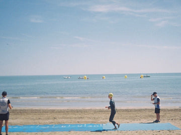 Triathletes running out of the water and onto the beach during the swim to run transition of a triathlon race