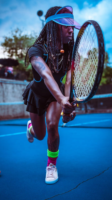 Tennis player mid swing hitting a forehand on an outdoor hard court
