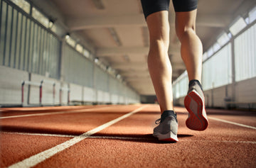 Fit athlete training on a running track, focusing on breathing technique during exercise