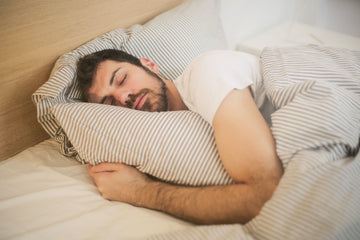 Man sleeping soundly on his side in bed, breathing through his nose