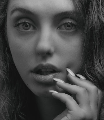 Close up of a person touching the sensitive skin on the side of their nose