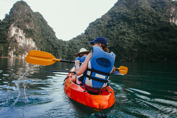Kayakers paddling across open sea water in bright daylight