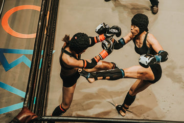 Two MMA athletes sparring in protective gear, working close range exchanges during a training session