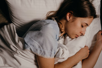 Woman sleeping peacefully on a white pillow, illustrating the benefits of nasal breathing for better sleep