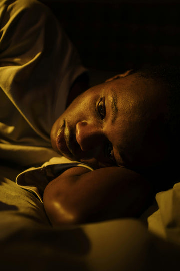 Man lying awake in bed at night struggling with blocked nose and sleep disruption from deviated septum