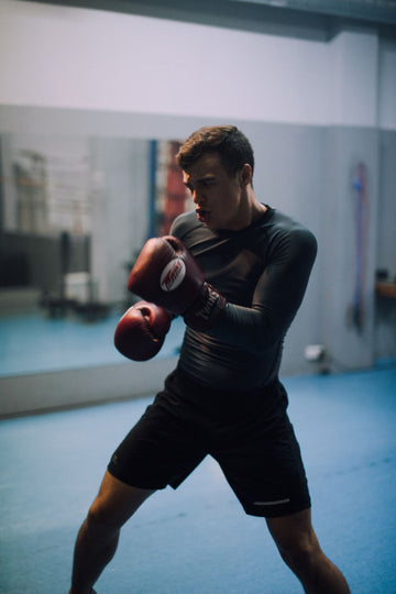 Boxer throwing a punch during a training session, the kind of high intensity effort where nasal breathing and nasal strips help most between rounds